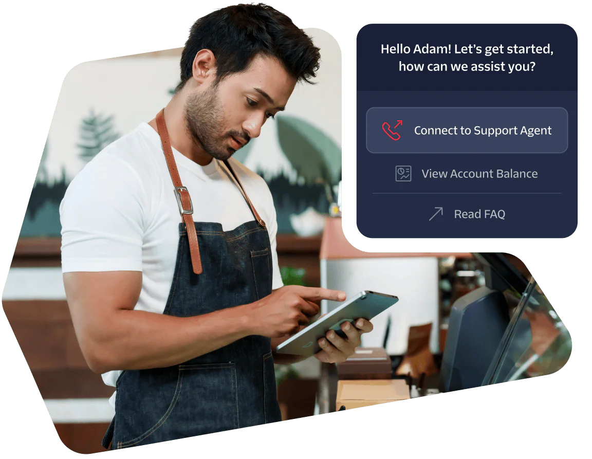 A barista in an apron using a tablet with a customer support prompt displayed on the screen.