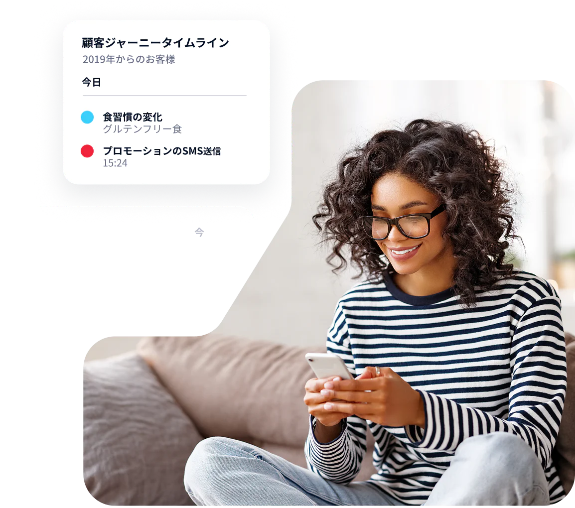 Woman with curly hair and glasses using a phone while receiving messages on a customer journey timeline.