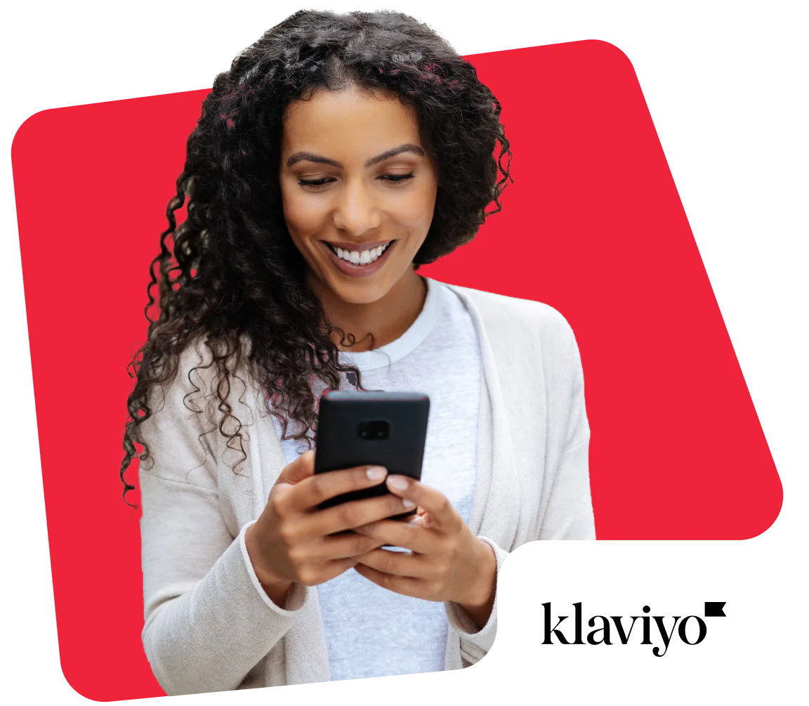 Smiling woman looking at smartphone with Klaviyo logo in the corner.