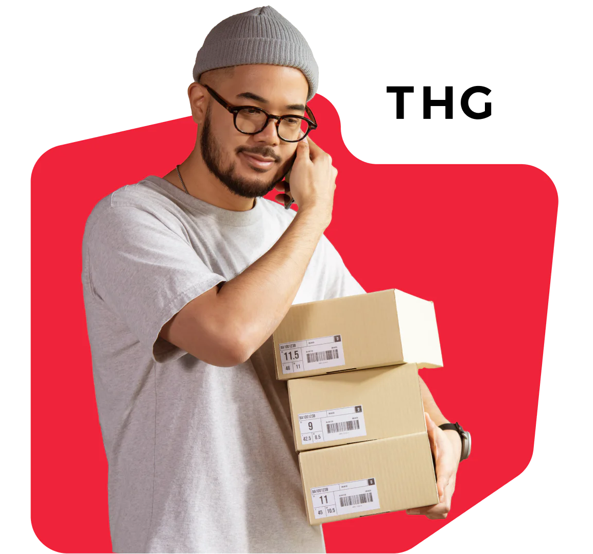 Man in grey beanie and glasses holding packages with THG logo on red background.