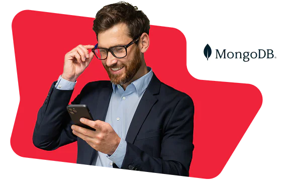 Man in suit looking at smartphone with MongoDB logo on red background.