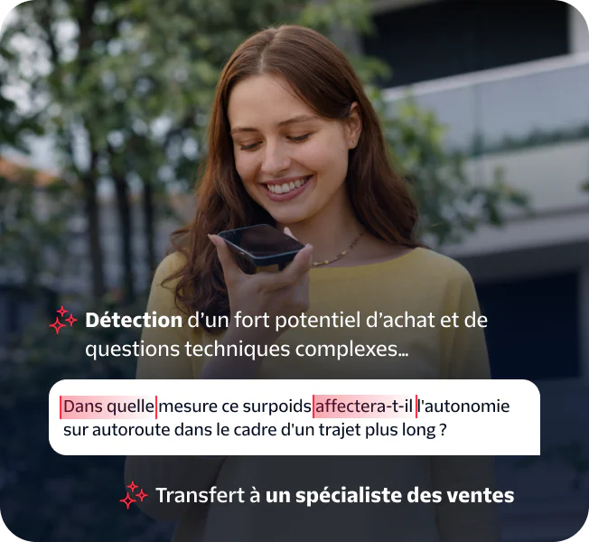 Woman speaking into a smartphone held in her hand while standing outside.