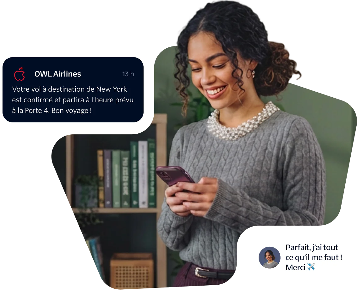 Woman smiling and looking at her phone while holding a flight confirmation message.