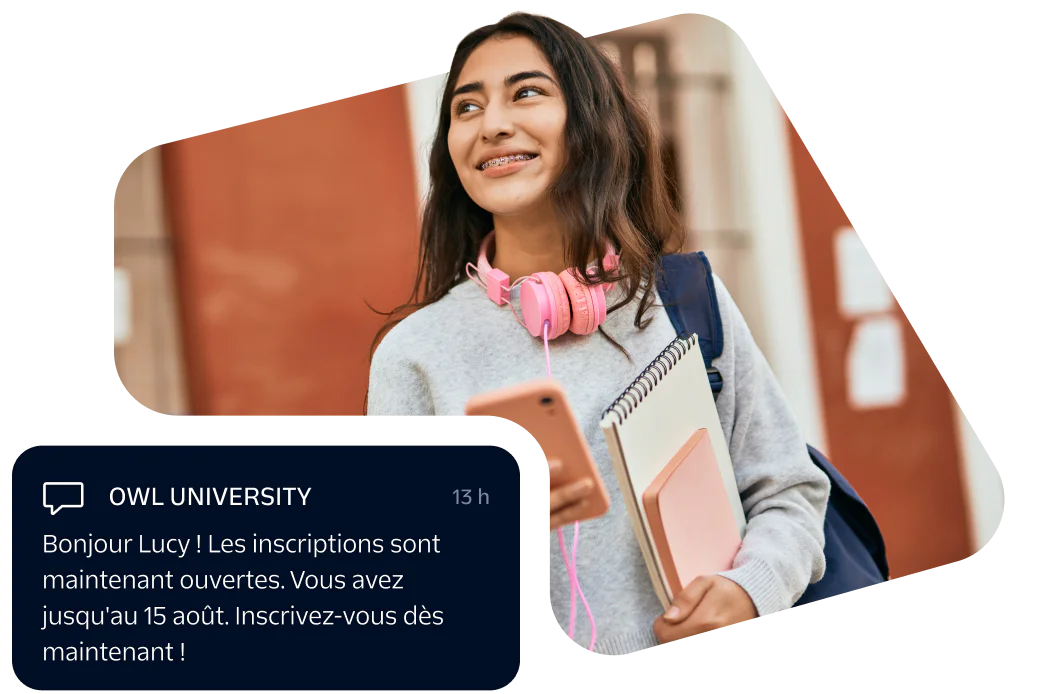 Smiling student with pink headphones, holding books and phone, receiving registration message from university.