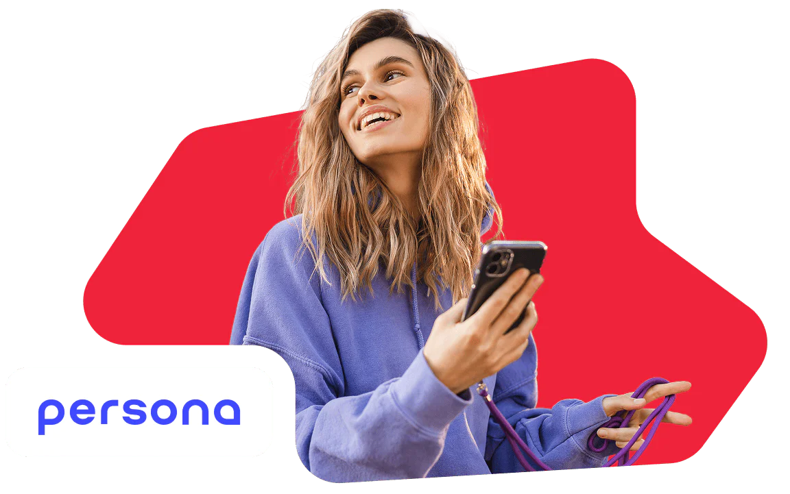 Smiling woman in a purple hoodie holding a smartphone with a red background.