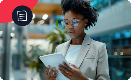 Woman in blazer and glasses using a tablet in a modern office setting