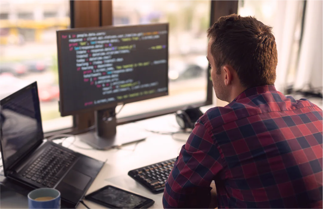 A man in an IDE on a desktop computer