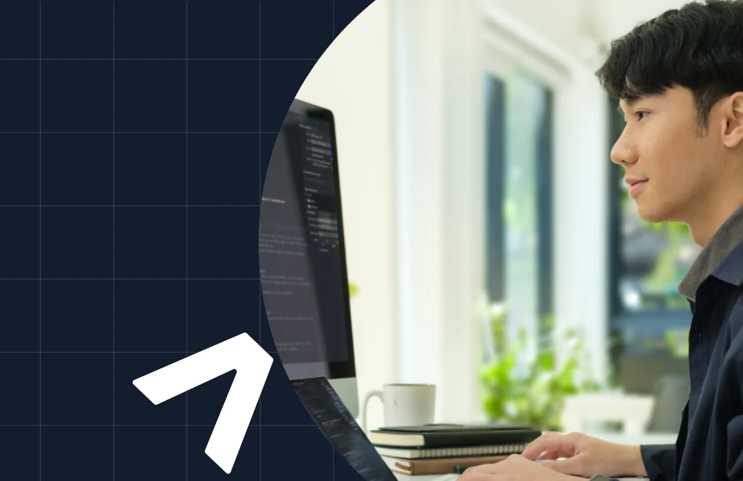 Man working on computer with coding software in a well-lit, modern office