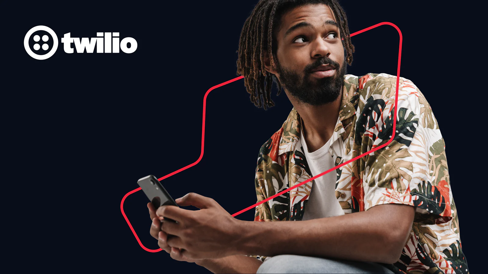 Man in tropical shirt looking to the side while holding a smartphone, with Twilio logo in background.