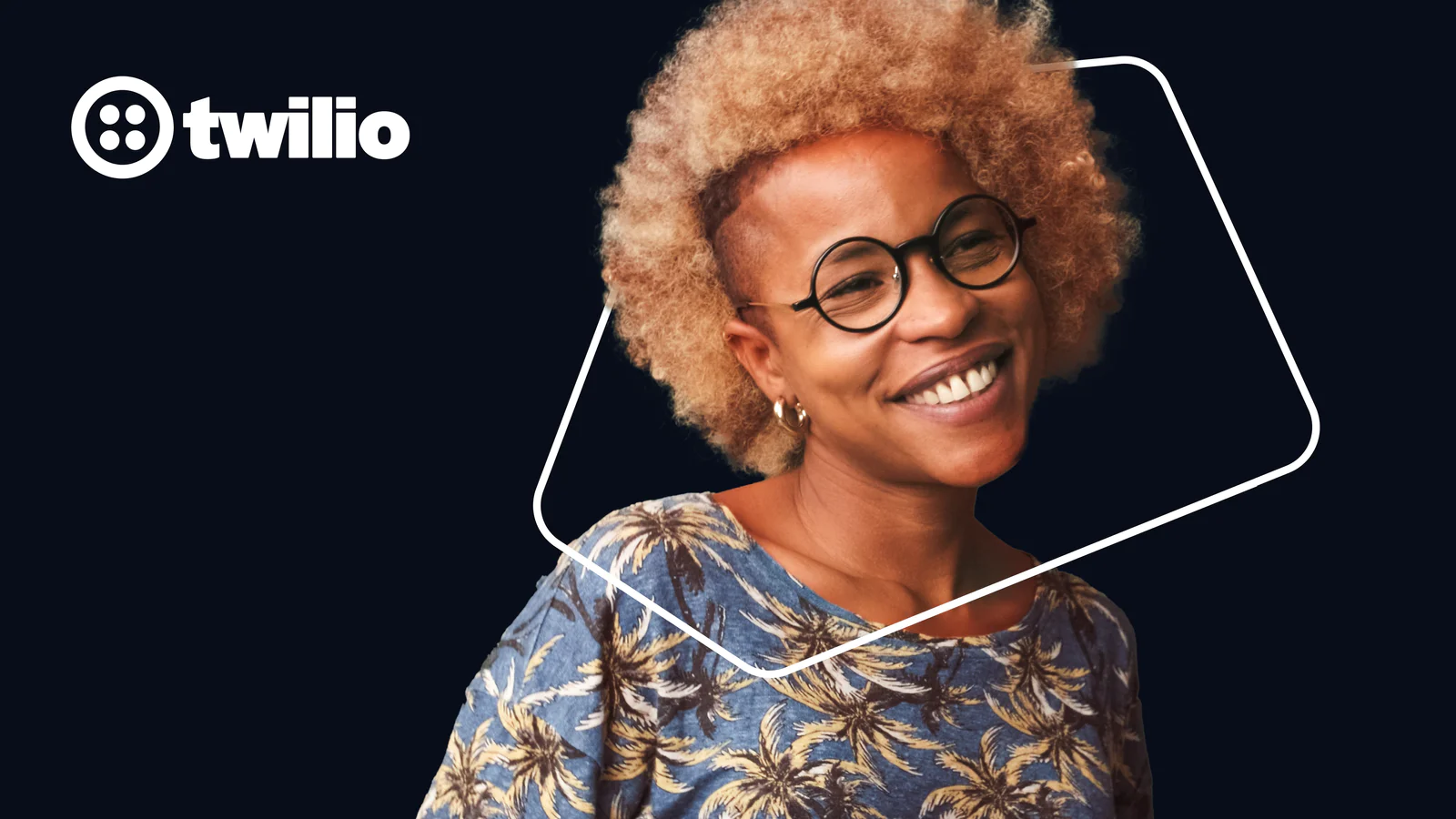 Person with curly hair and glasses smiling, Twilio logo in the background