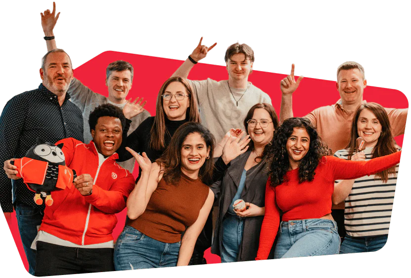 Group of ten people smiling and raising arms, showing excitement and camaraderie.