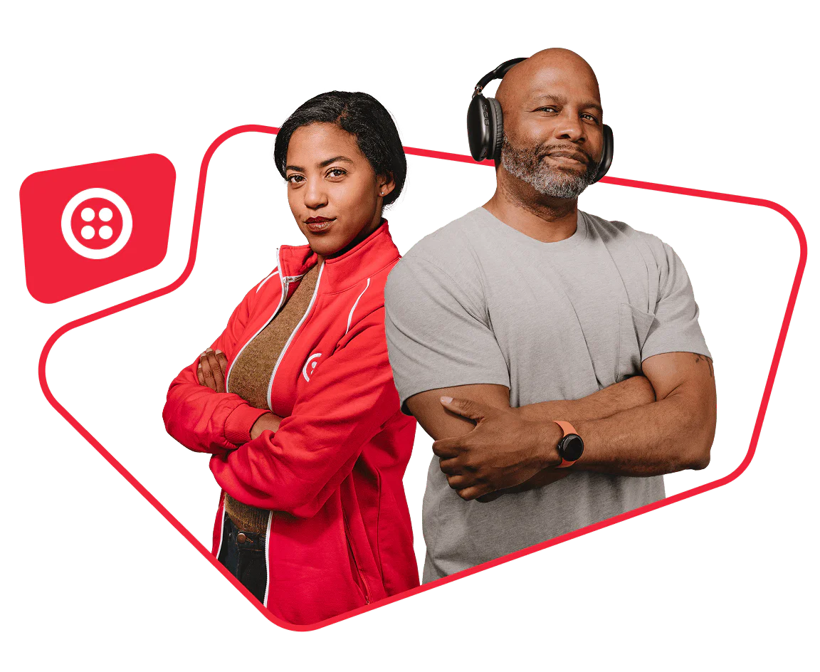 Man wearing headphones and woman in a red jacket with arms crossed, standing side by side