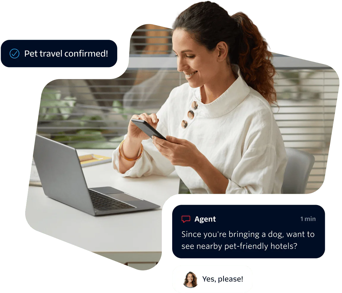 Woman using phone while chatting with virtual agent about pet-friendly hotels, laptop on desk.
