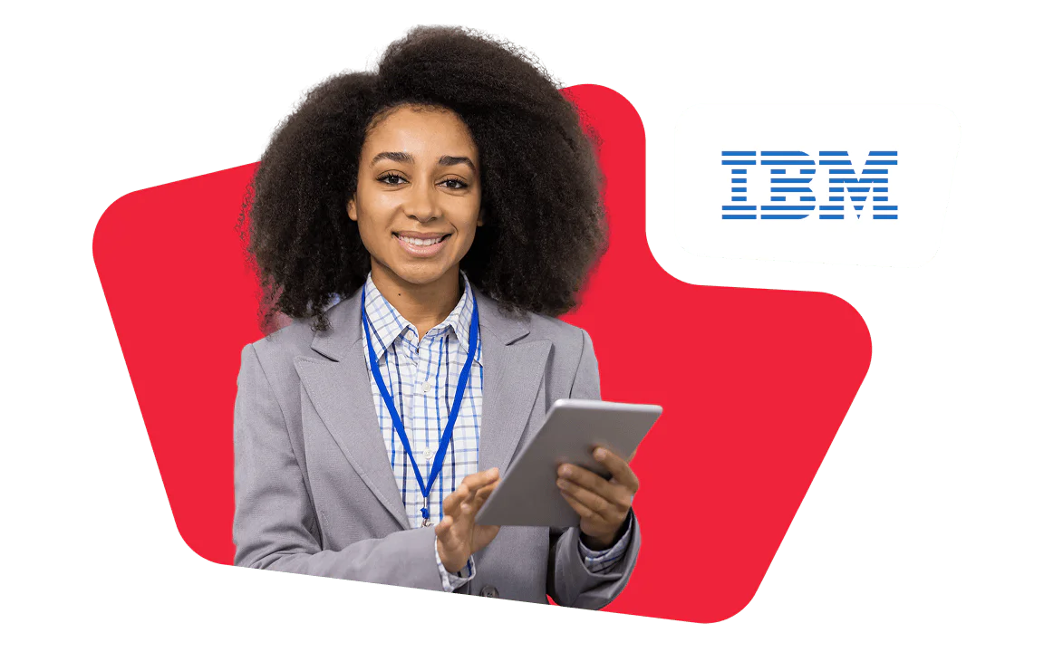 Woman in a gray suit holding a tablet, standing in front of IBM logo with red background.