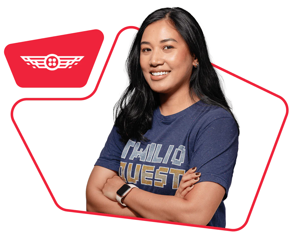 Woman with long black hair and folded arms wearing a blue graphic t-shirt and a watch.