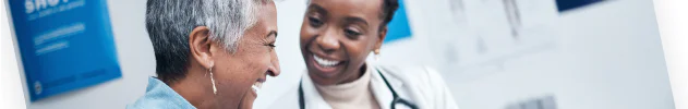 Doctor and patient smiling and talking in a medical office.