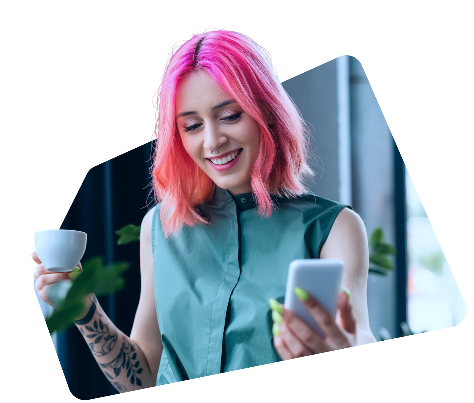 Smiling woman with pink hair holding a smartphone and a cup of coffee.