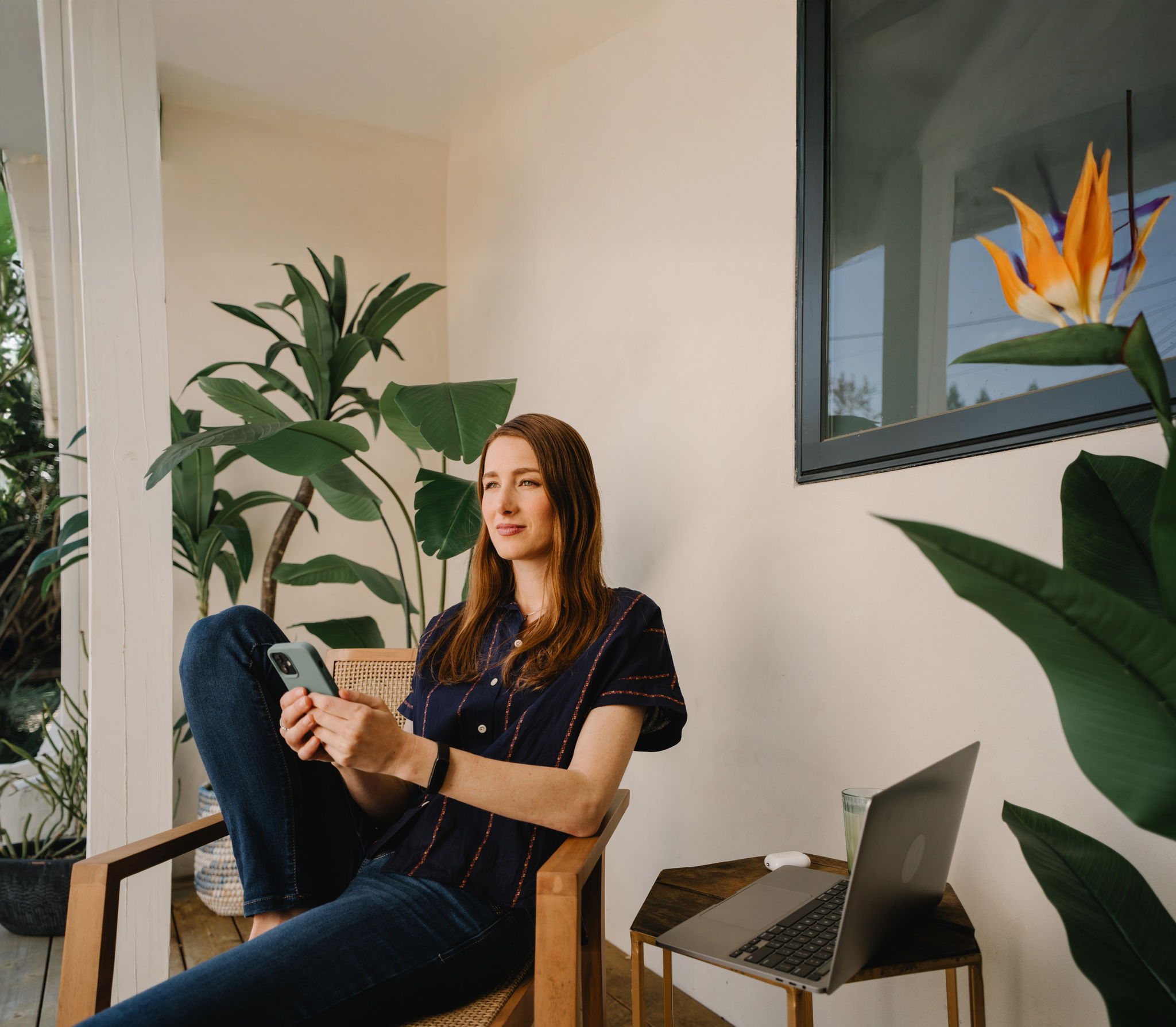 Woman Relaxing on a Porch with Laptop and Smartphone