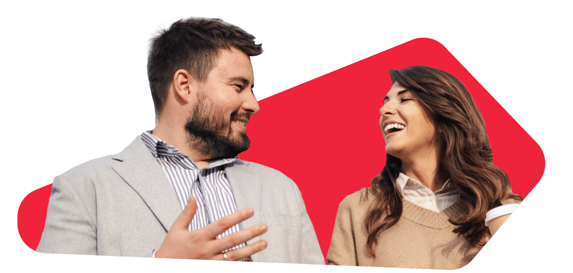 Two people, a man and a woman, smiling and talking against a red background.