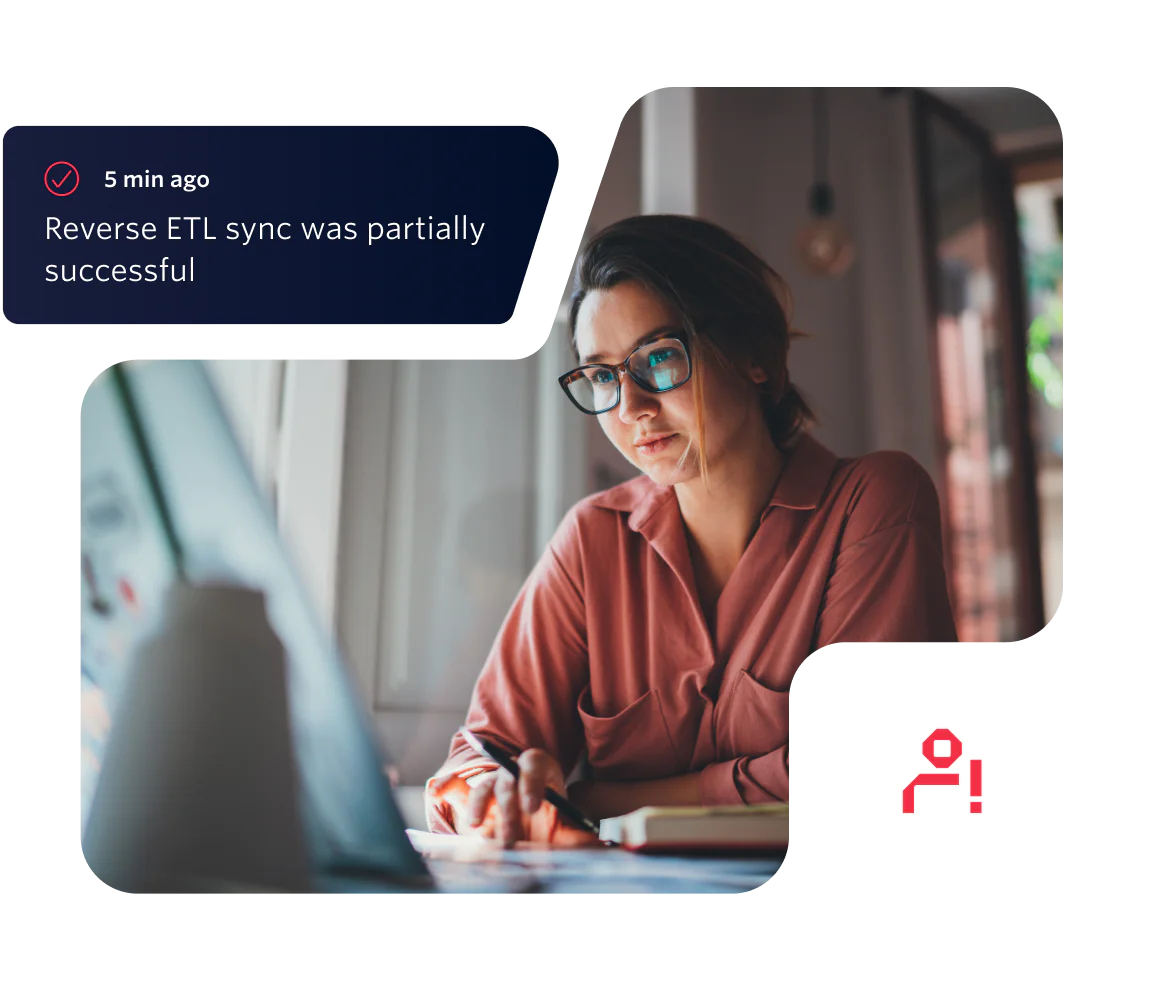 Woman wearing glasses and pink shirt working on a laptop with an ETL sync notification.