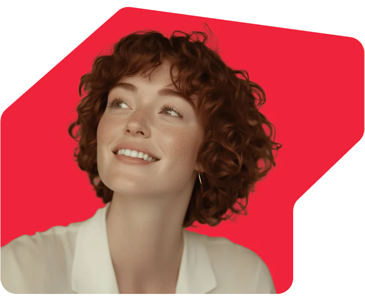 Woman with short curly hair smiling, set against a bright red background.