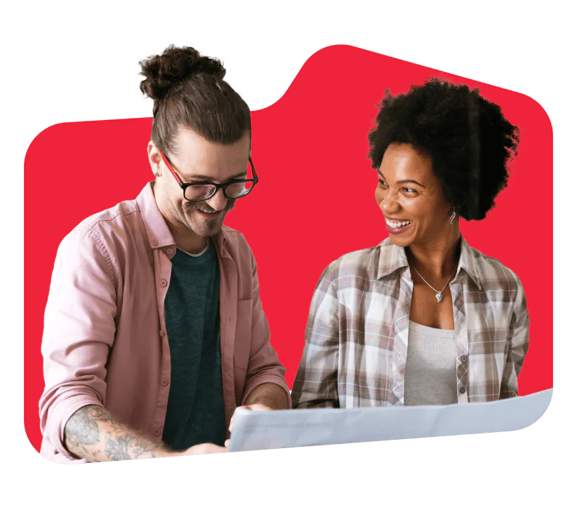 Two colleagues smiling and looking at a document together with a red background.