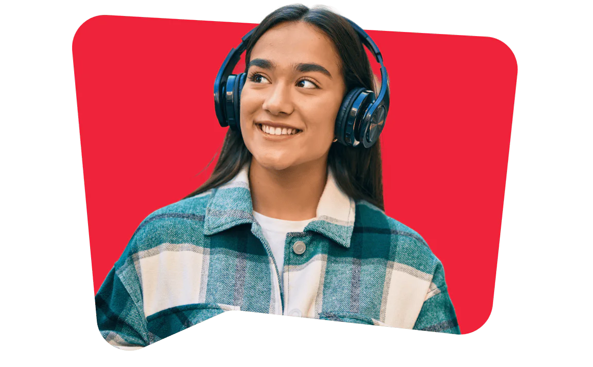 Woman wearing headphones and a plaid jacket, smiling while looking away.