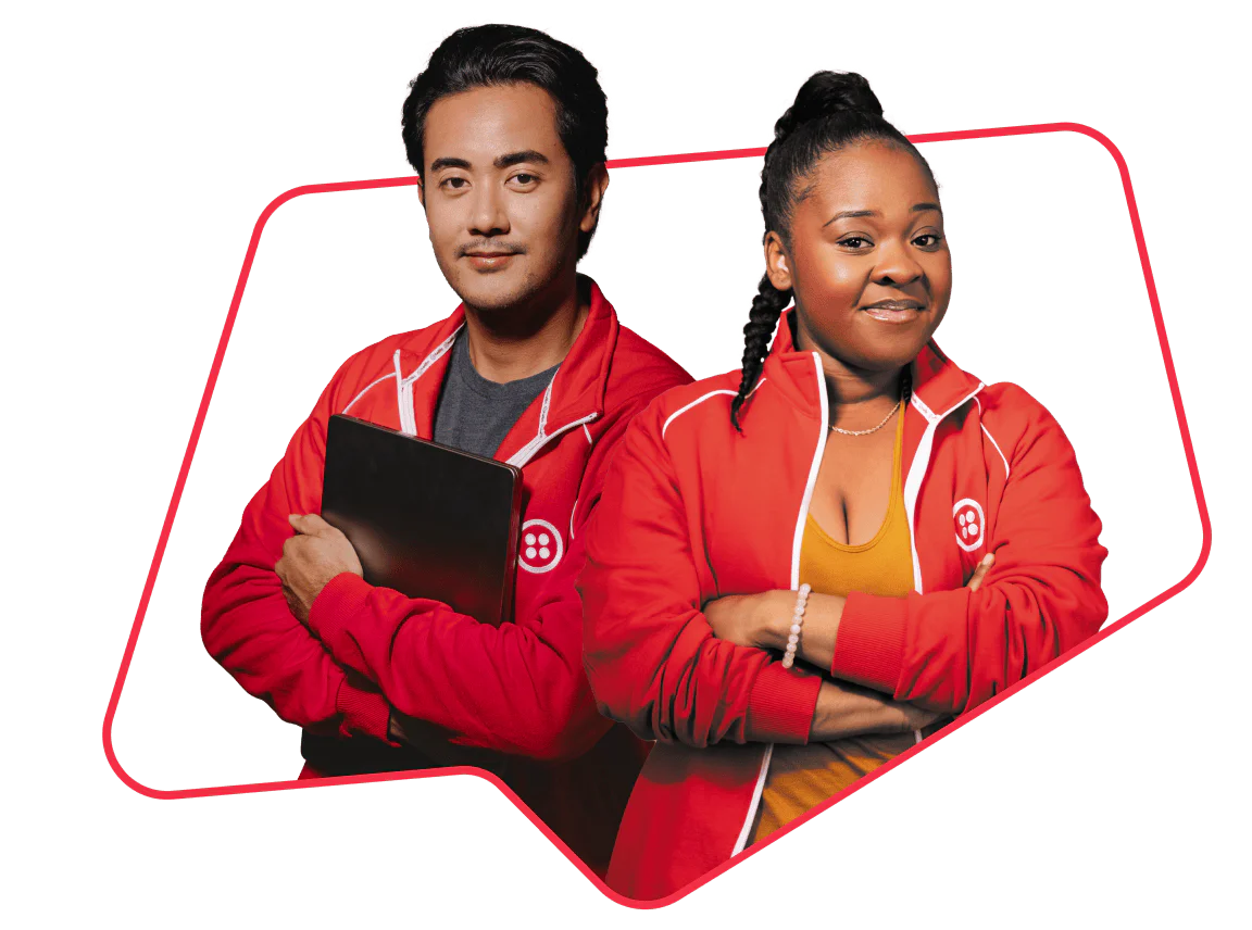 Two individuals wearing red jackets confidently pose with crossed arms.