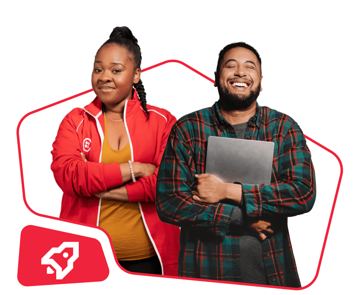 A woman in a red jacket and a man in a plaid shirt holding a laptop, both smiling.