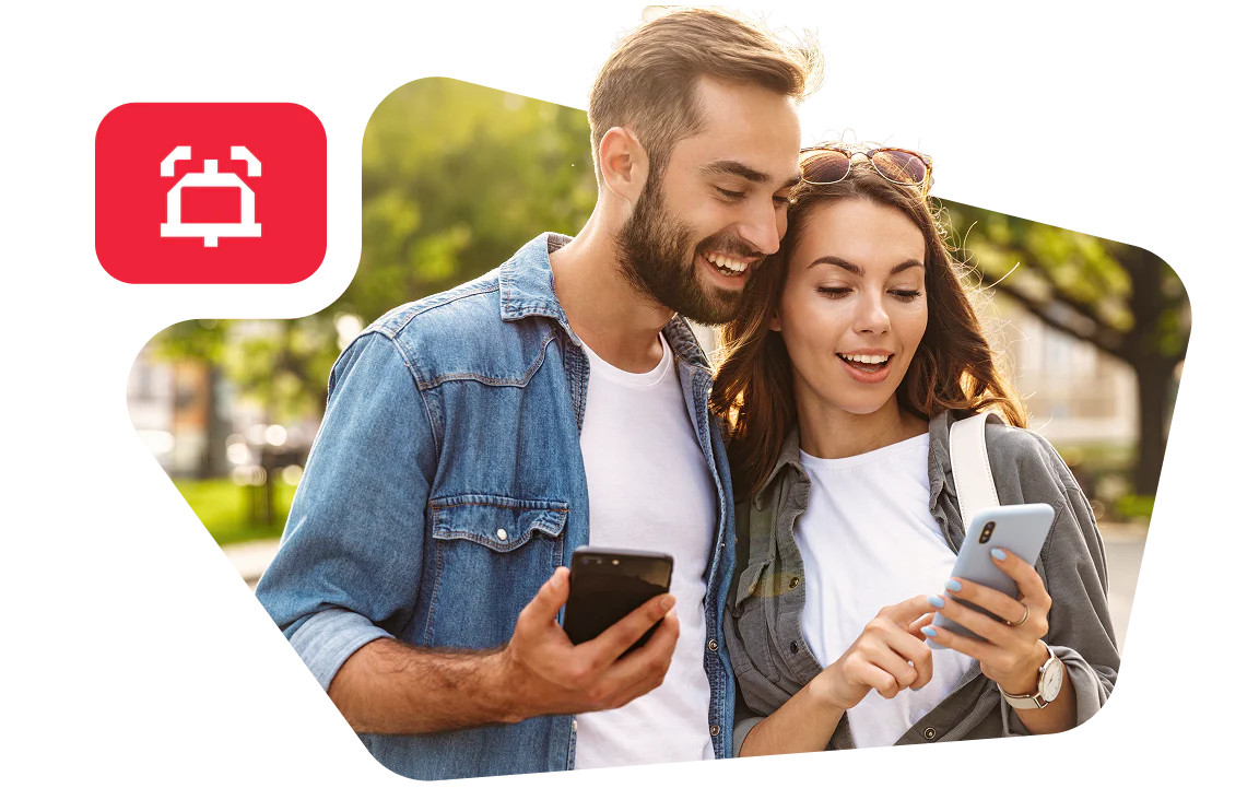 Couple Enjoying Time Together with Smartphones Outdoors Smiling couple looking at their smartphones while standing outside.