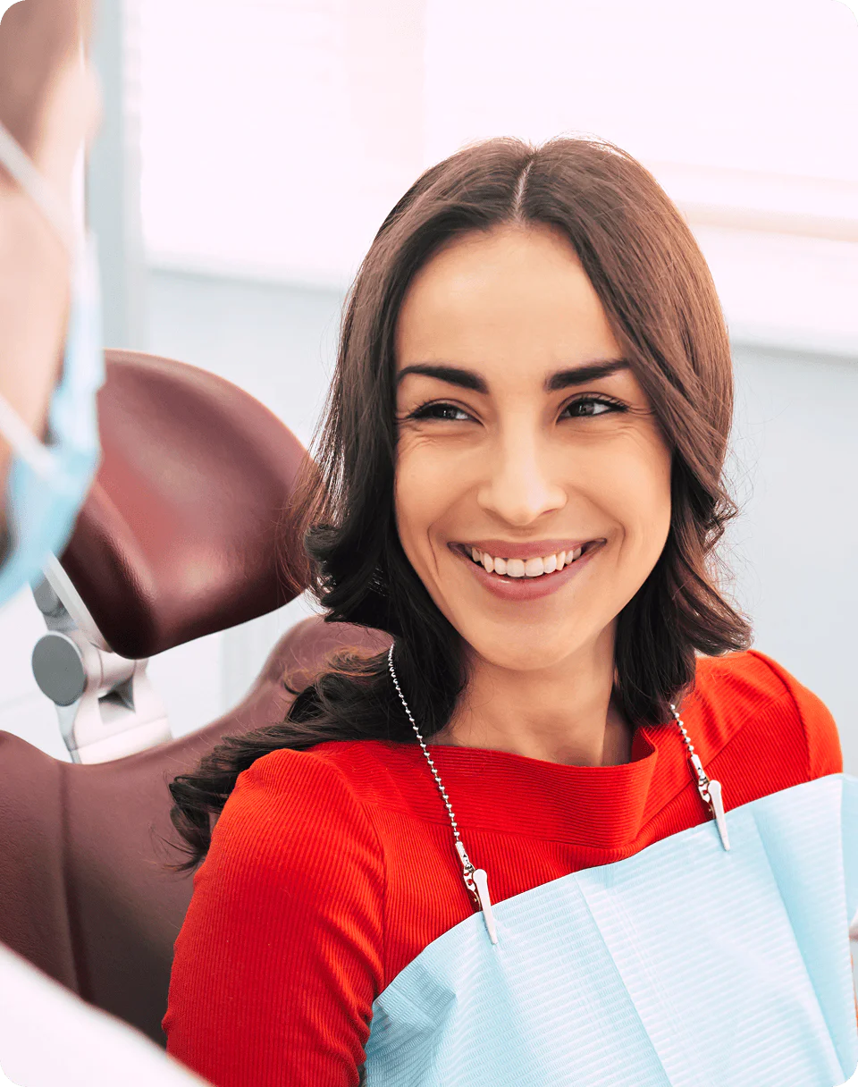 Smiling woman sitting in a dental chair during a dental consultation