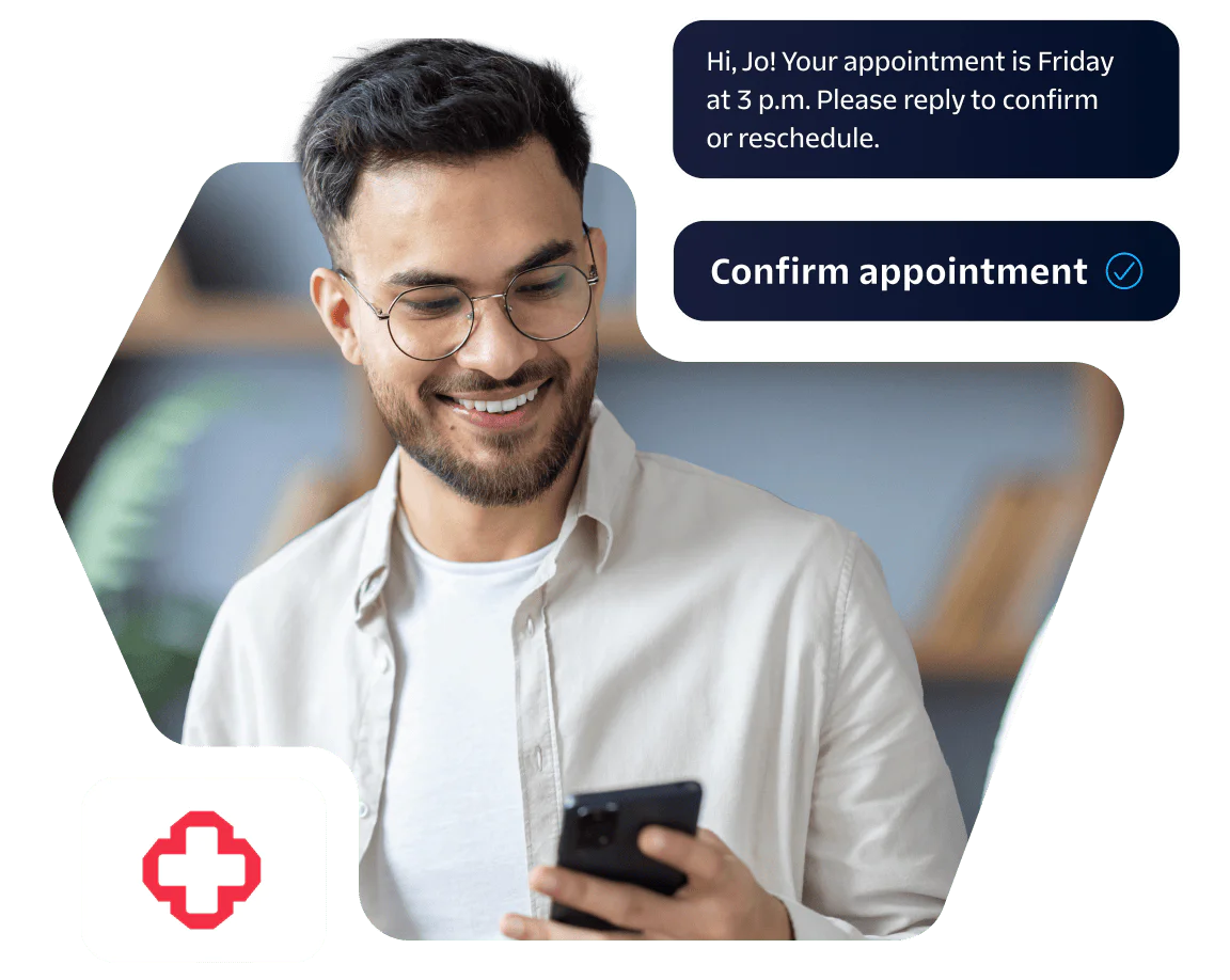 Man with glasses smiling at phone, confirming an appointment, medical cross icon visible.