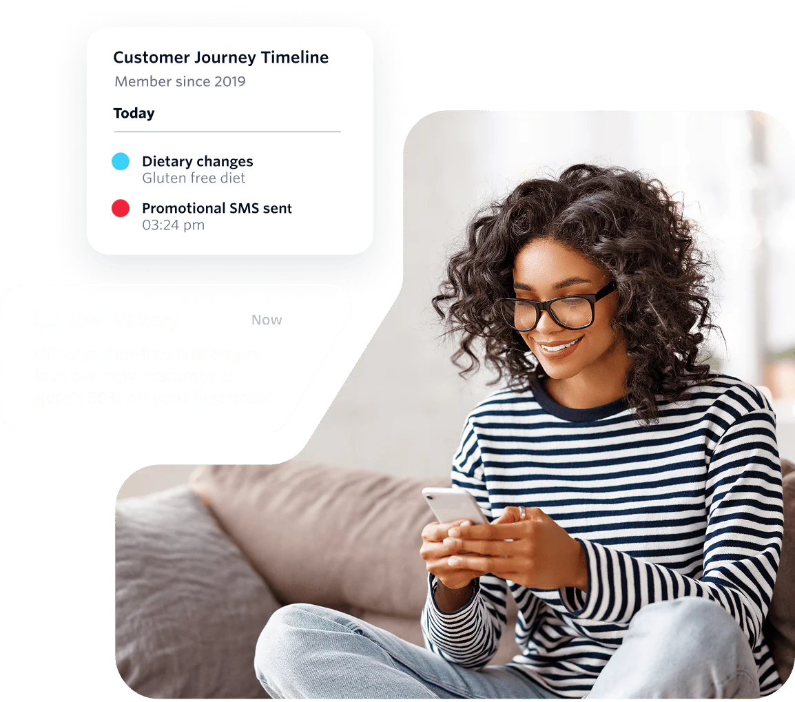 Woman with curly hair and glasses using a phone while receiving messages on a customer journey timeline.