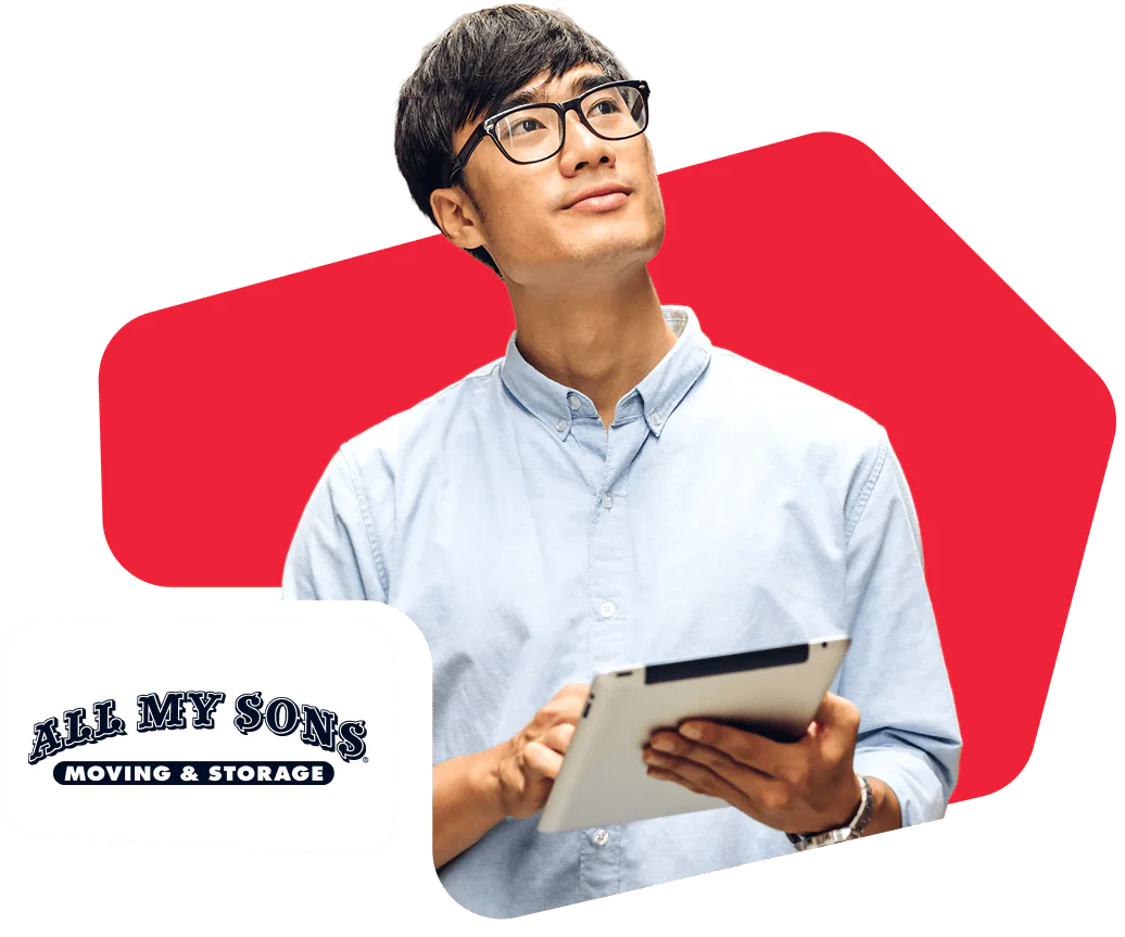 Man with glasses holding a tablet with All My Sons Moving & Storage logo in the background.