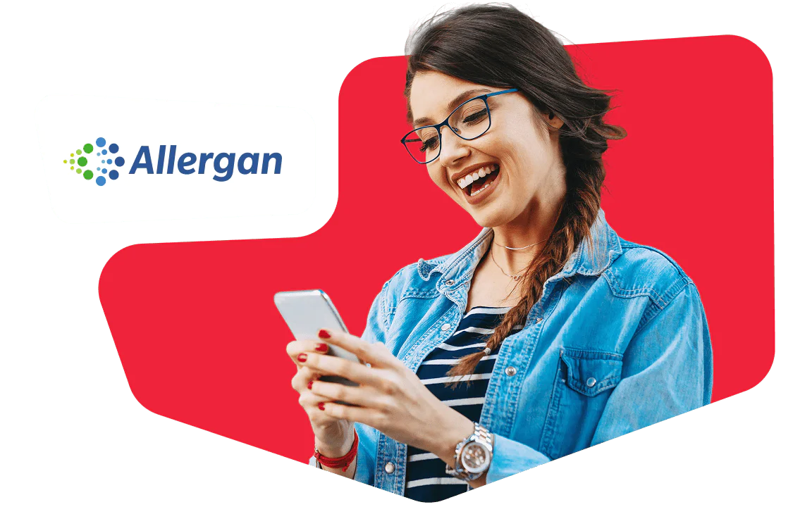 Woman in glasses and denim jacket smiling while looking at her smartphone, with Allergan logo in the background.