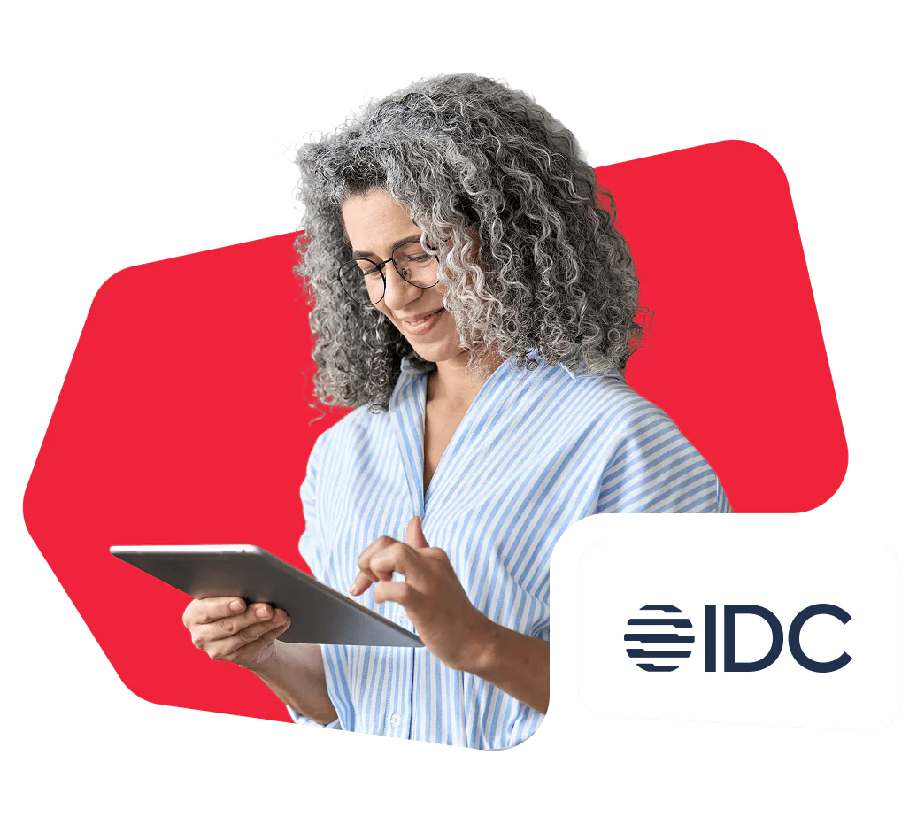 Woman with curly gray hair using a tablet, IDC logo in the corner.