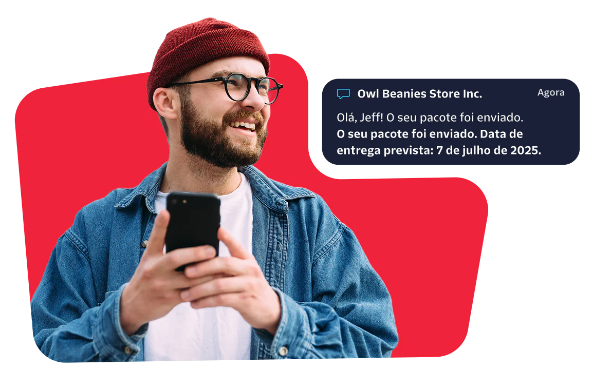Man receiving a package shipment notification Smiling man with a red beanie checks his phone for a message about his package delivery.